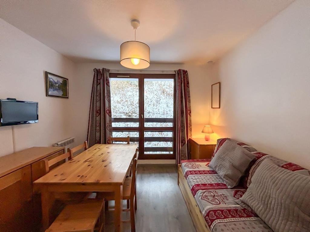un salon avec un canapé et une table en bois dans l'établissement Studio confortable 3 pers, proche pistes, quartier calme des Menuires - FR-1-452-38, aux Menuires