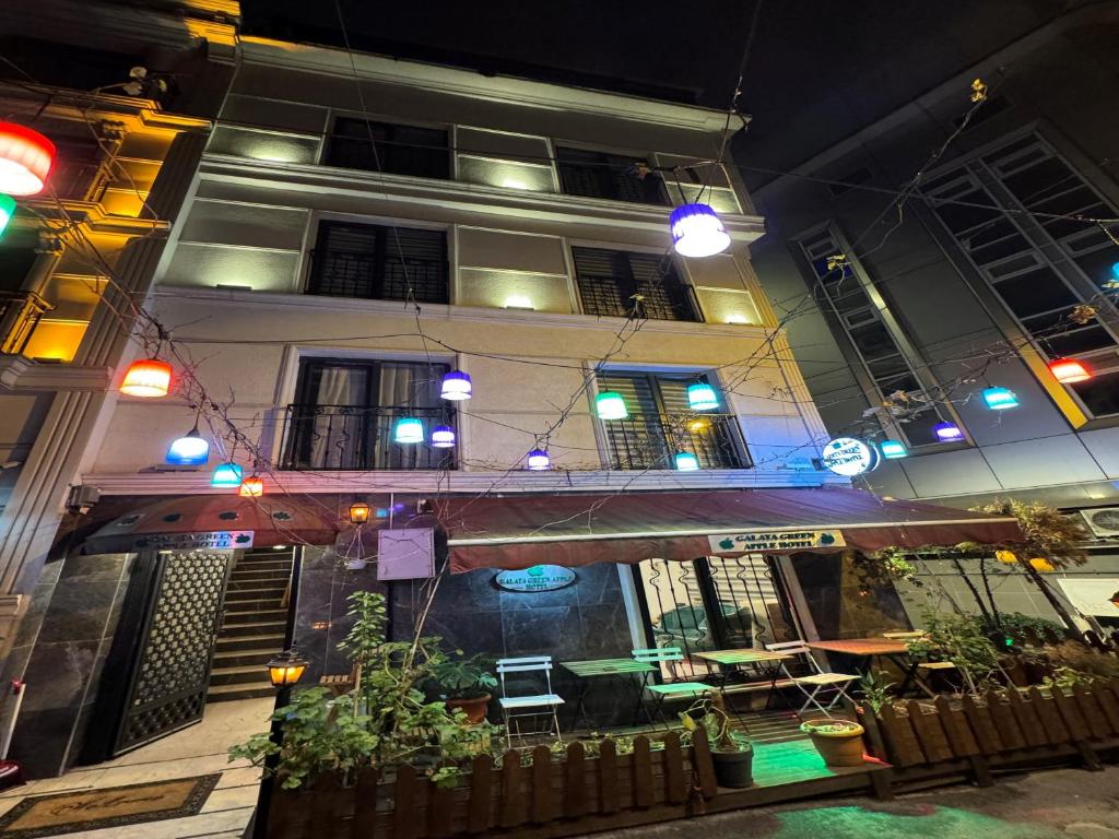 a building with a balcony in front of it at night at GALATAGREENAPPLEHOTEL in Istanbul