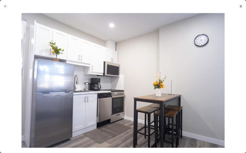 eine Küche mit einem Kühlschrank aus Edelstahl und einem Tisch in der Unterkunft 117 McGregor St Blenheim Unit # 3 in Blenheim