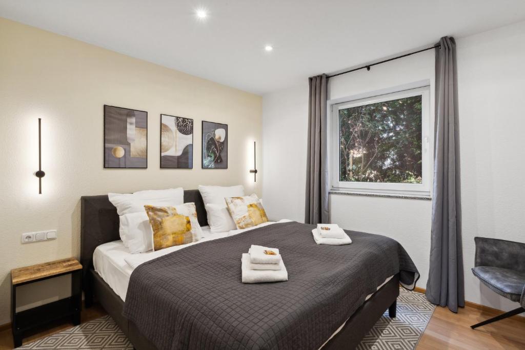 ハーメルンにあるCharysma - Aurum-Suite, modernes & elegantes Design, Parkplatz, Terrasseの大きなベッドとタオル2枚のある寝室