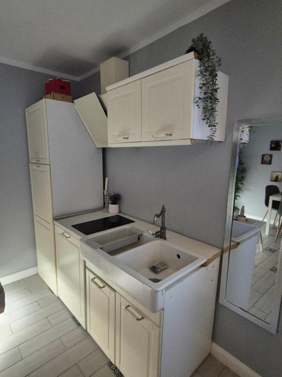 une cuisine avec des armoires blanches et un évier dans l'établissement HUGO Luxury Brand New 2 Bedrooms Apartment in the Center, à Craiova