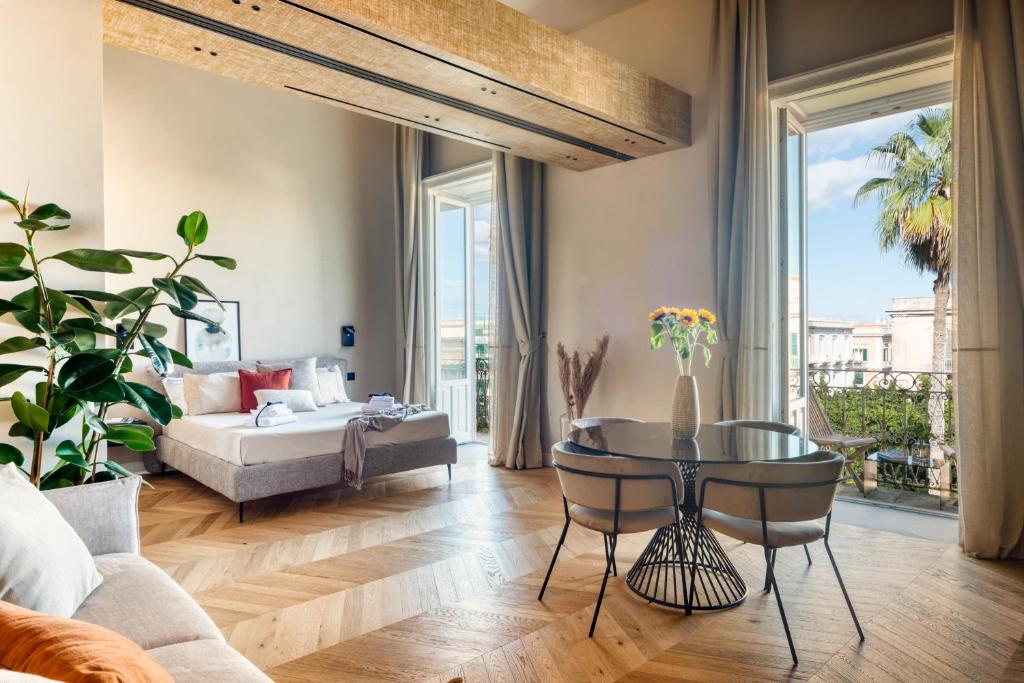 een woonkamer met een bed en een tafel bij THE PLACE Ortigia in Siracusa