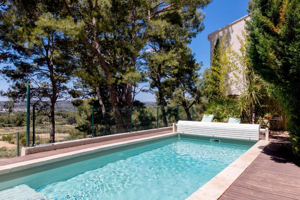 une piscine avec un banc à côté d'une maison dans l'établissement Villa Le Mas des Roches à 15mn airport Marseille, à Velaux