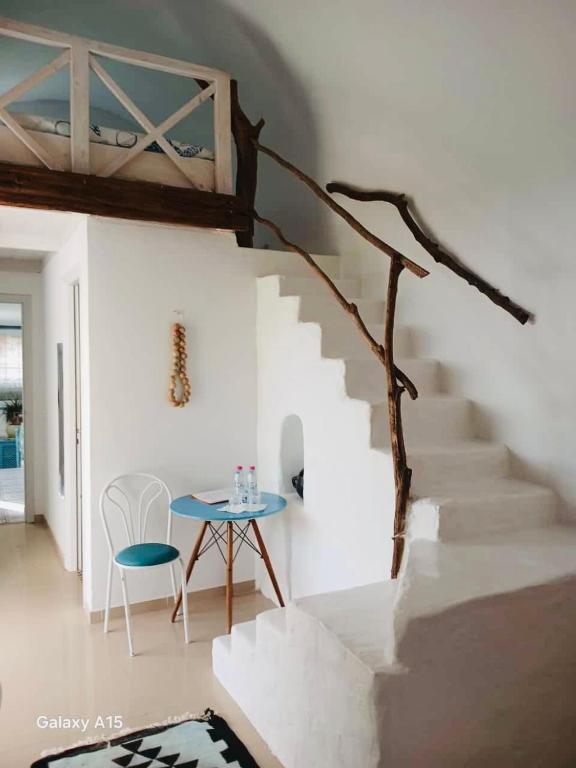 a white room with a staircase with a blue table at Dar El Mahdia by Daldoul in Mahdia