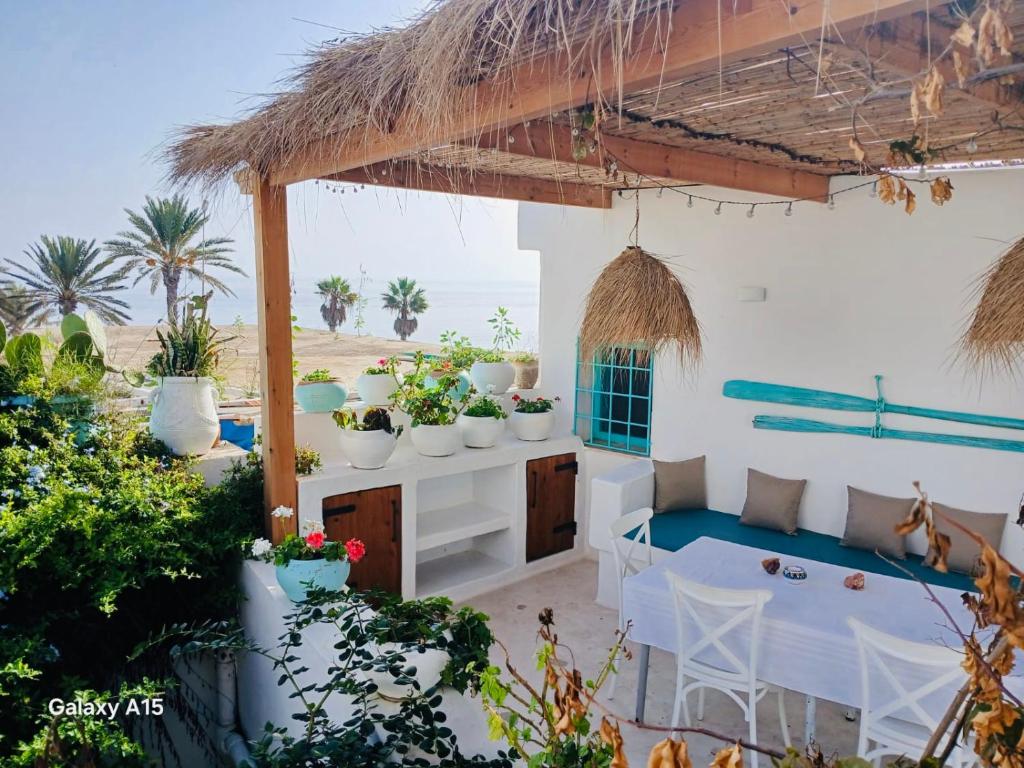 a patio with a table and chairs and plants at Dar El Mahdia by Daldoul in Mahdia