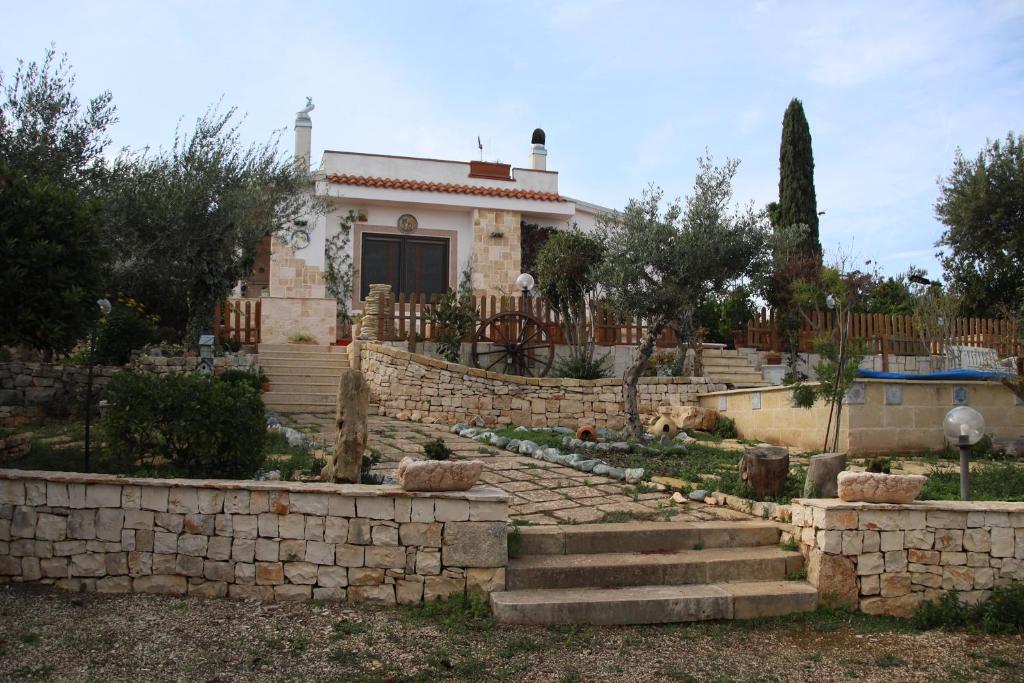 a house with a retaining wall and a yard at villa lanterna in Conversano