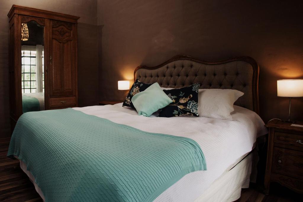Un dormitorio con una cama grande con almohadas. en El Pinar Caballeriza, en San Rafael