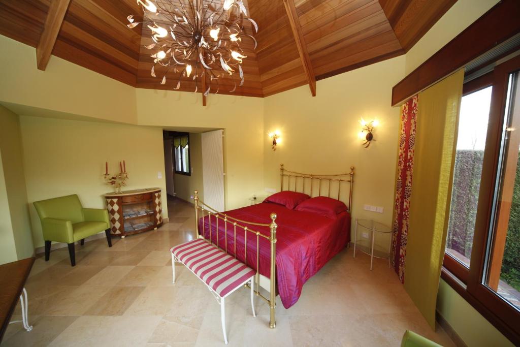 a bedroom with a red bed and a chair at La Coulonnière in Wismes