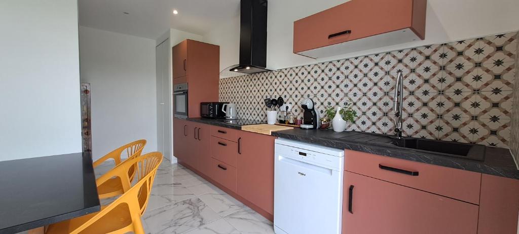 una cucina con mobili rossi e un piano di lavoro di La Maison Chehaa a Bias