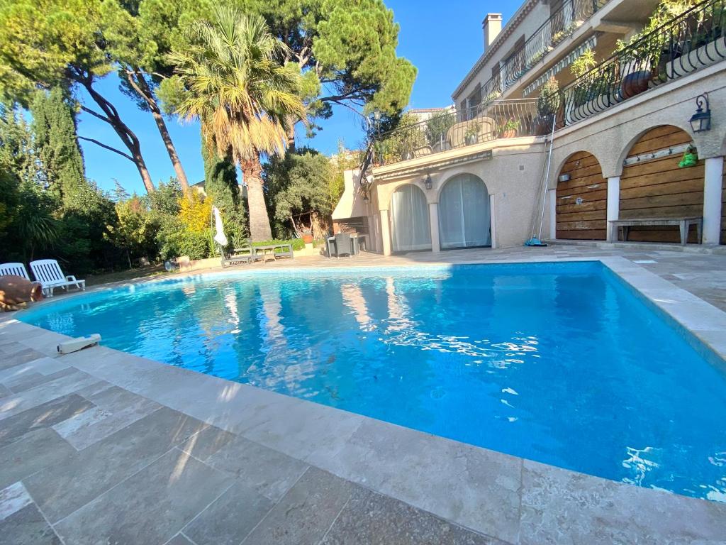 une piscine devant une maison avec des arbres dans l'établissement Les ormeaux, à Marseille