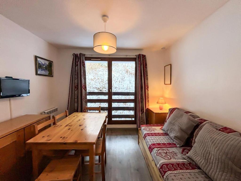 un salon avec un canapé et une table en bois dans l'établissement Résidence Argousier - Studio 3 pers au coeur des Menuires MAE-5874, aux Menuires