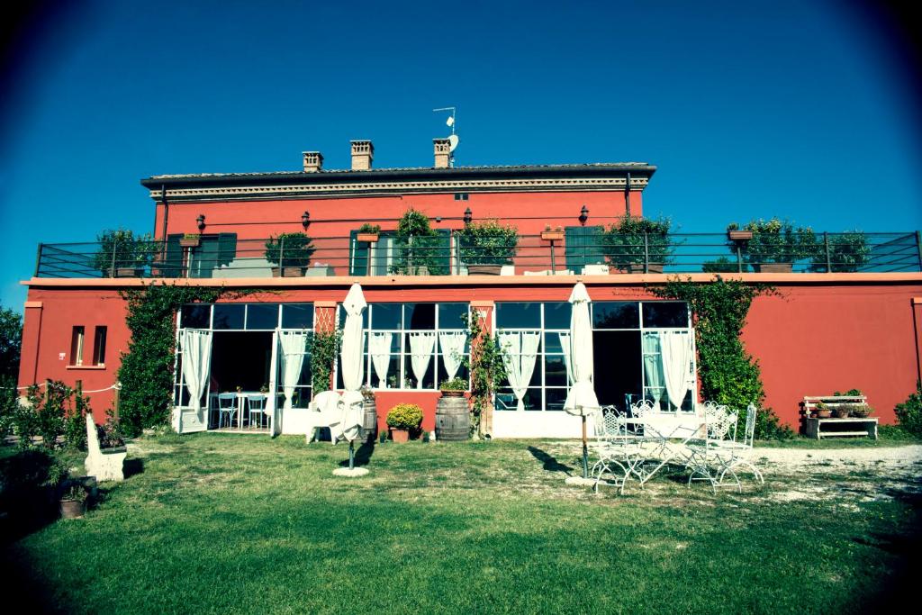 a large red building with a yard in front of it at Tenuta Santini in Coriano