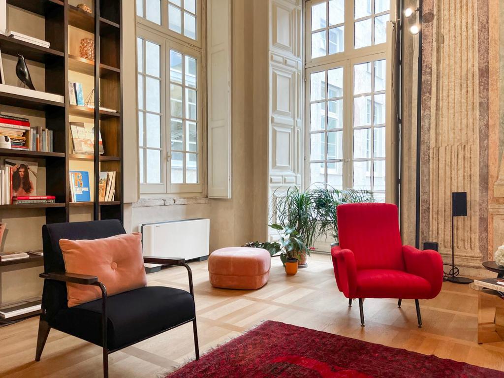 salon z 2 krzesłami i czerwonym krzesłem w obiekcie Hotel Palazzo Grillo w Genui