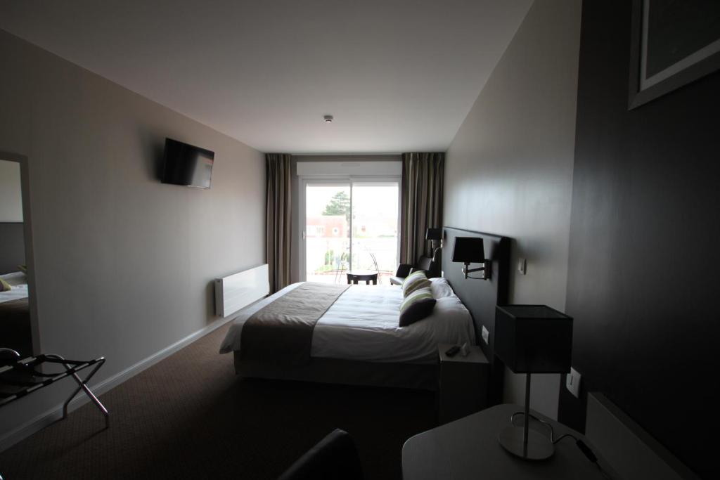 une chambre d'hôtel avec un lit et une fenêtre dans l'établissement Hôtel Le Cheval Blanc, à Quend-Plage
