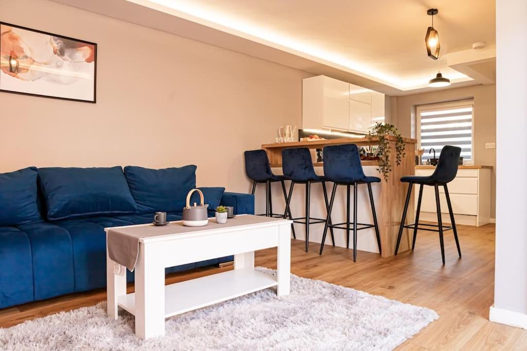 a living room with a blue couch and a table at Detached 2 Bedroom House - 10 minute's walk to Town Centre - Free Parking, Fast Wifi and Smart TVs by Tejza Property in Rugby