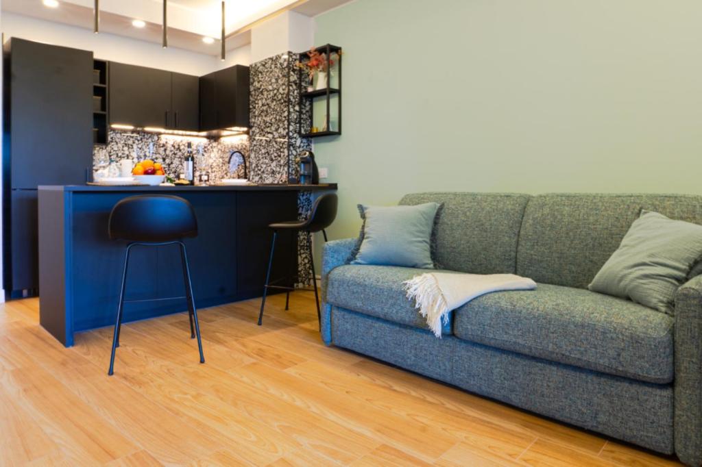 een woonkamer met een bank en een keuken bij HOLIDAYS HOMES ROME GOLF Appartamenti Marco Simone AeB in Marco Simone