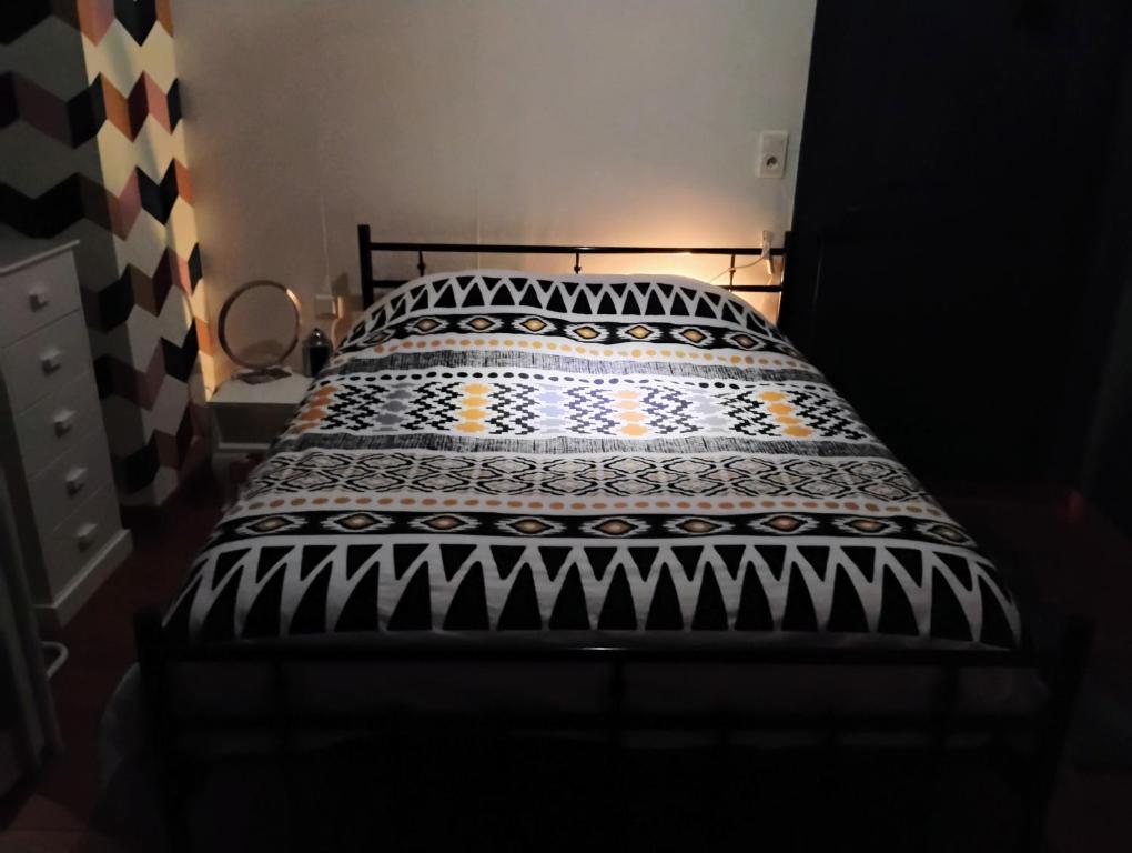 Una cama con un edredón blanco y negro. en Gîte avec parking, au calme, entre Colmar-Riquewihr et Obernai ,marchés de Noël, 3 chambres, avec terrasse, en Châtenois