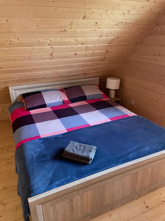 Postel nebo postele na pokoji v ubytování Karmelowe Domki Kaszuby, z jacuzzi na tarasie z widokiem na jezioro