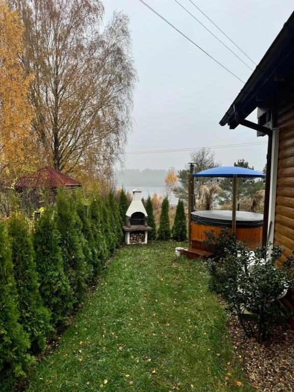 Zahrada ubytování Karmelowe Domki Kaszuby, z jacuzzi na tarasie z widokiem na jezioro