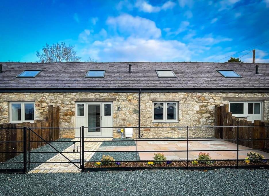 a stone house with a fence in front of it at Tractor Shed, seaside cosy cottage for 4 in Beaumaris