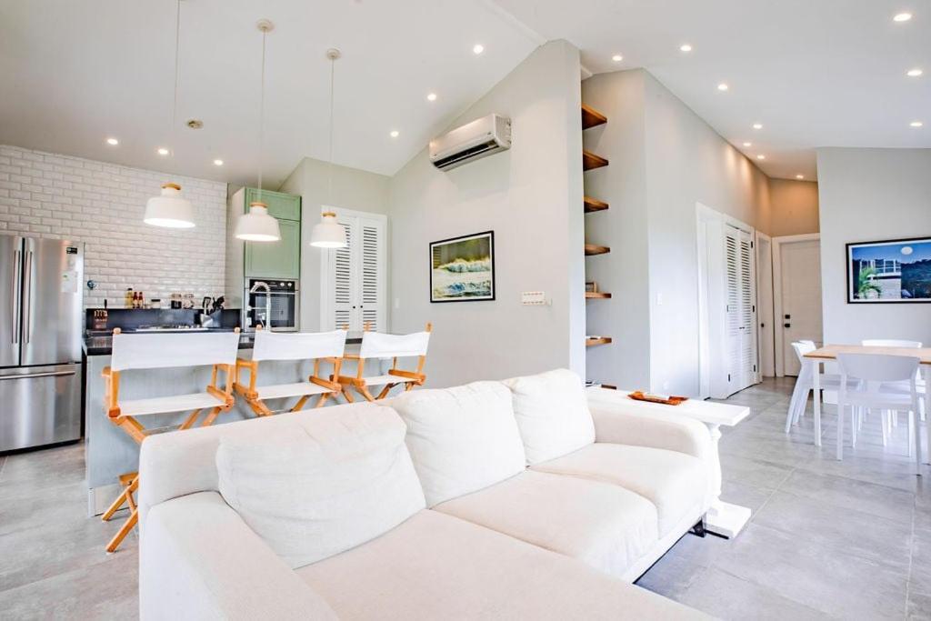 a living room with a white couch and a kitchen at Family Perfect Getaway 3BR Villa 6 at Playa Venao in Playa Venao
