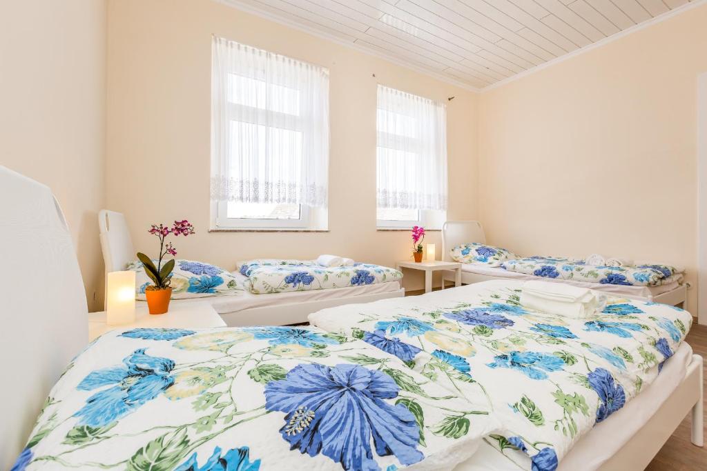 1 Schlafzimmer mit 2 Betten und 2 Fenstern in der Unterkunft Apartments Leverkusen in Leverkusen