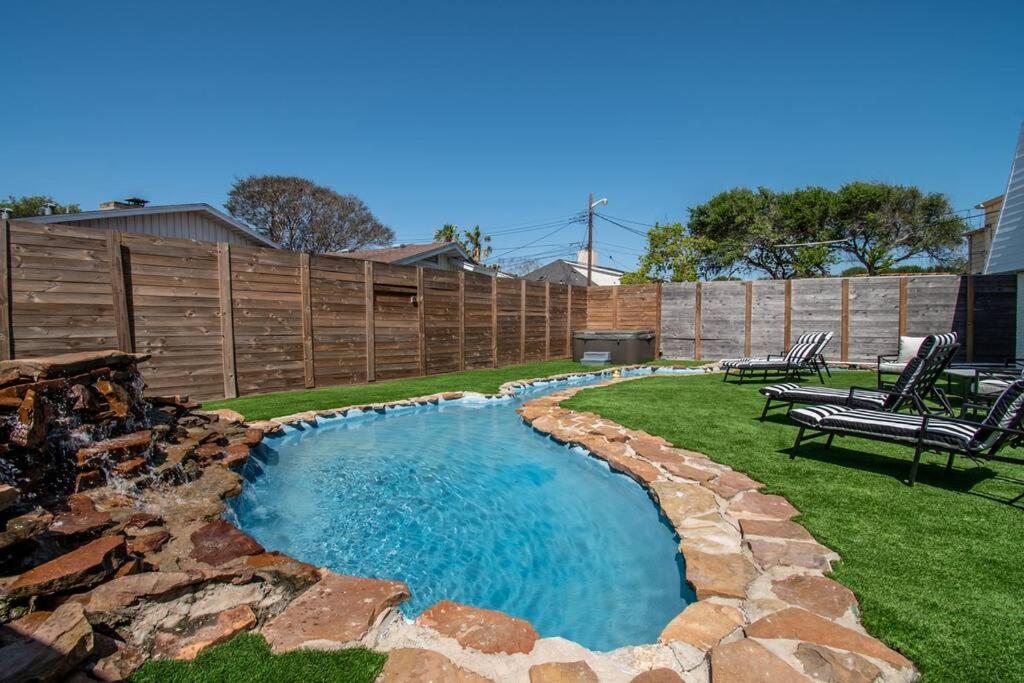 a backyard with a swimming pool and a fence at Oceanfront Retreat 2 Homes for 29-Guests in Corpus Christi