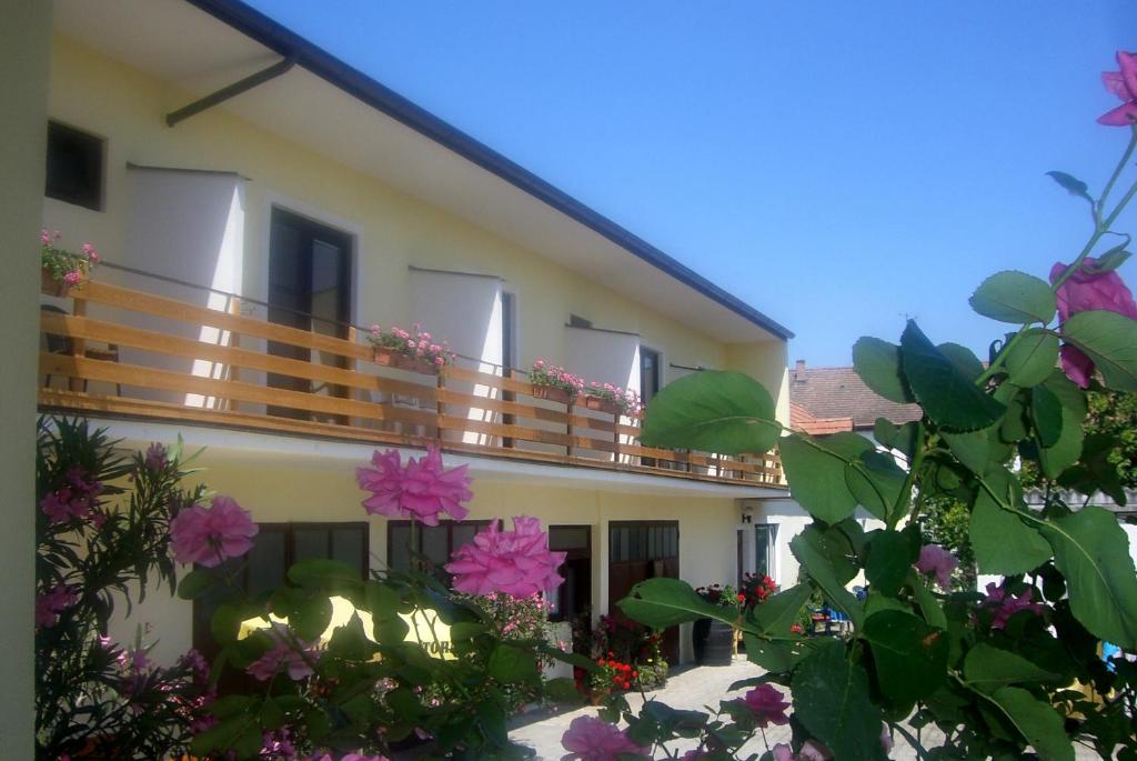 - un bâtiment avec un balcon orné de fleurs roses dans l'établissement Gästehaus Elfriede, à Mörbisch am See