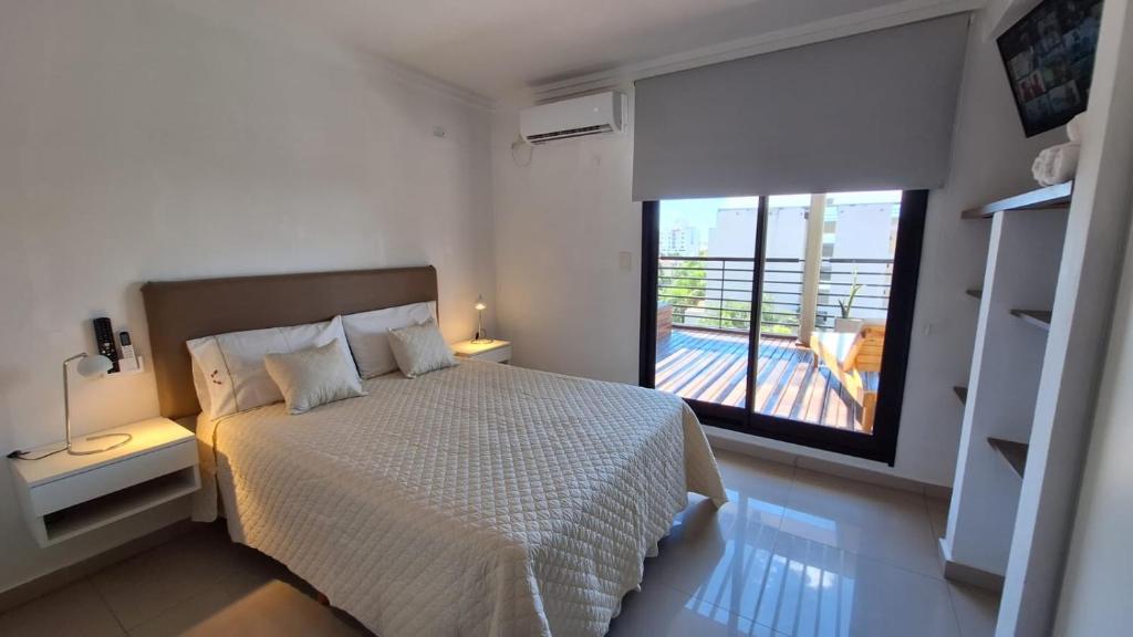 een slaapkamer met een bed en een groot raam bij 3 Personas - Balcon, Wifi & Cafe in Santiago del Estero