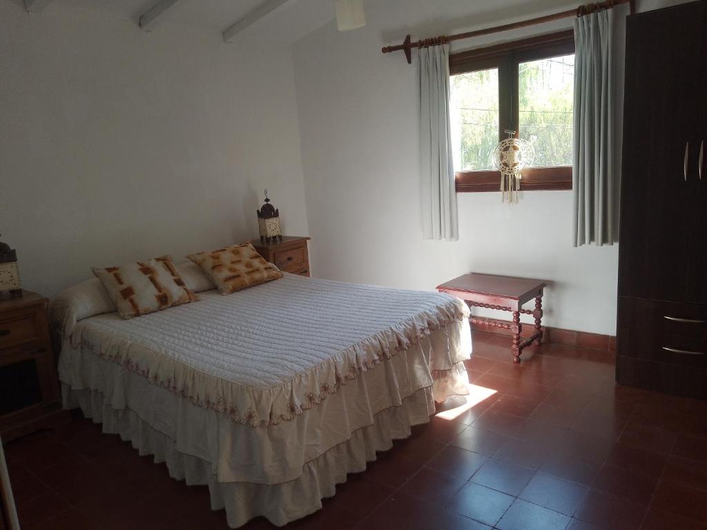 a bedroom with a bed and a window at La Casa de los Pájaros in Tanti