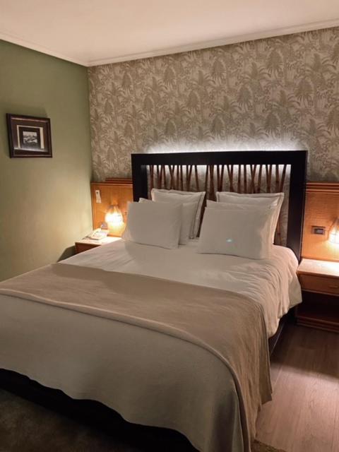 um quarto com uma cama grande e um computador porttil. em Hotel Lusitano em Vilar Formoso