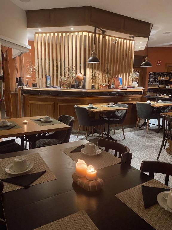 uma sala de jantar com mesas e cadeiras e um bar em Hotel Lusitano em Vilar Formoso
