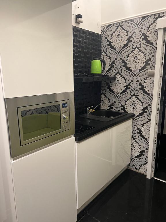 eine kleine Küche mit Mikrowelle und Spüle in der Unterkunft Fashion street mini apartment in Budapest