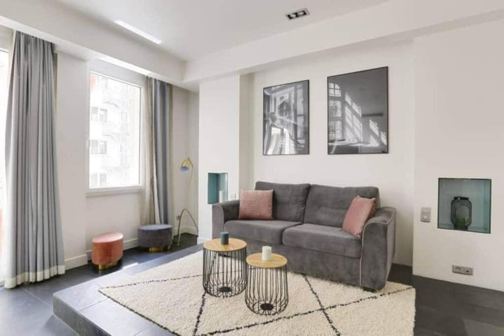 un salon avec un canapé et deux tables dans l'établissement Appartement cosy près du Marais, à Paris