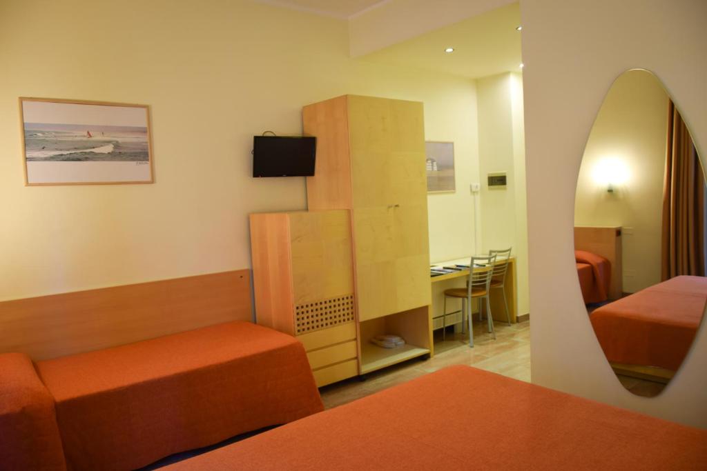 pokój z sypialnią z łóżkiem i lustrem w obiekcie Hotel Losanna w Mediolanie
