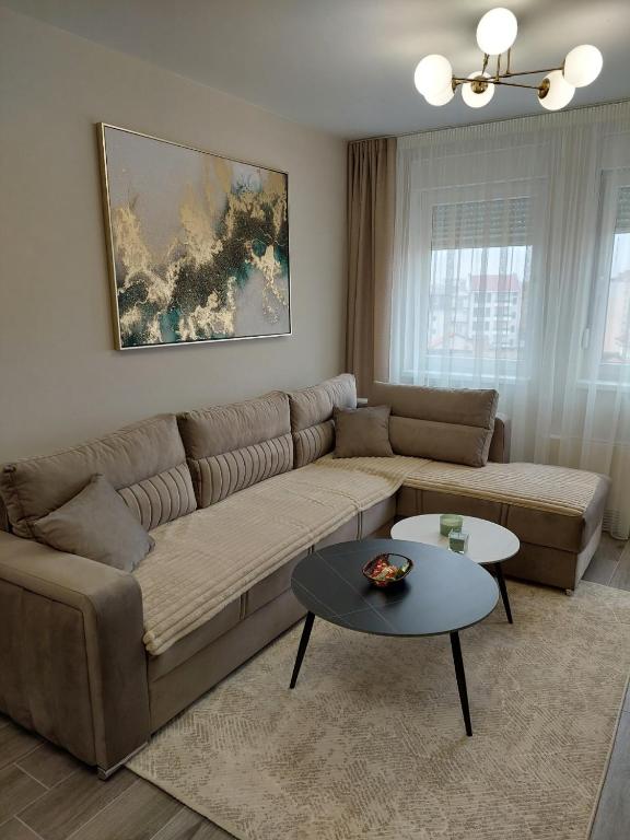 a living room with a couch and a table at Royal Apartman in Bijeljina