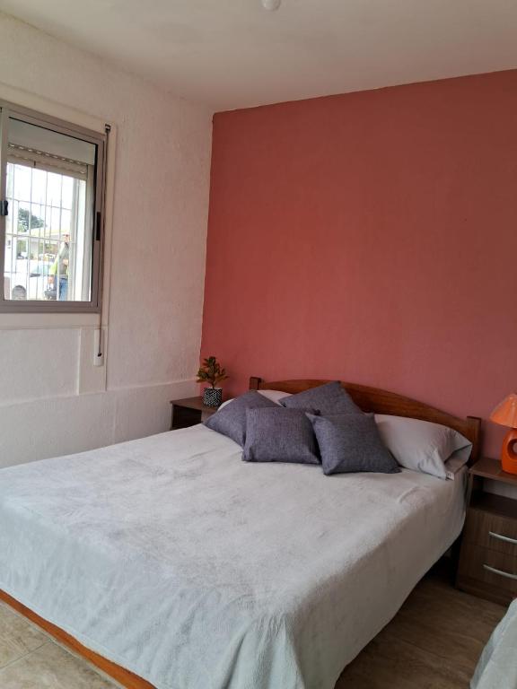 a bedroom with a bed and a red wall at Casita en Florida in Florida