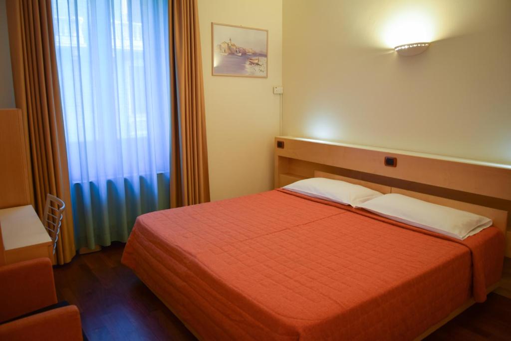 Łóżko lub łóżka w pokoju w obiekcie Hotel Losanna