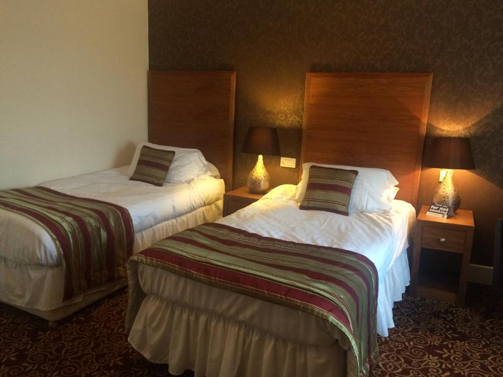 A bed or beds in a room at The Three Tuns Hotel Wetherspoon 