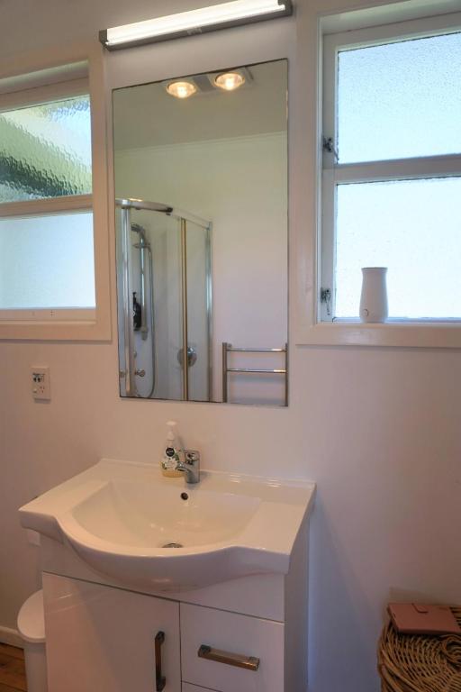 un bagno con lavandino e specchio di LAST ON THE STRAND, RUSSELL - The BOATHOUSE a Russell