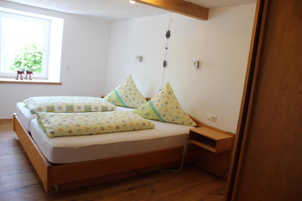 1 dormitorio con cama con almohadas y ventana en Ferienwohnung Bergkristall, en Immenstadt im Allgäu