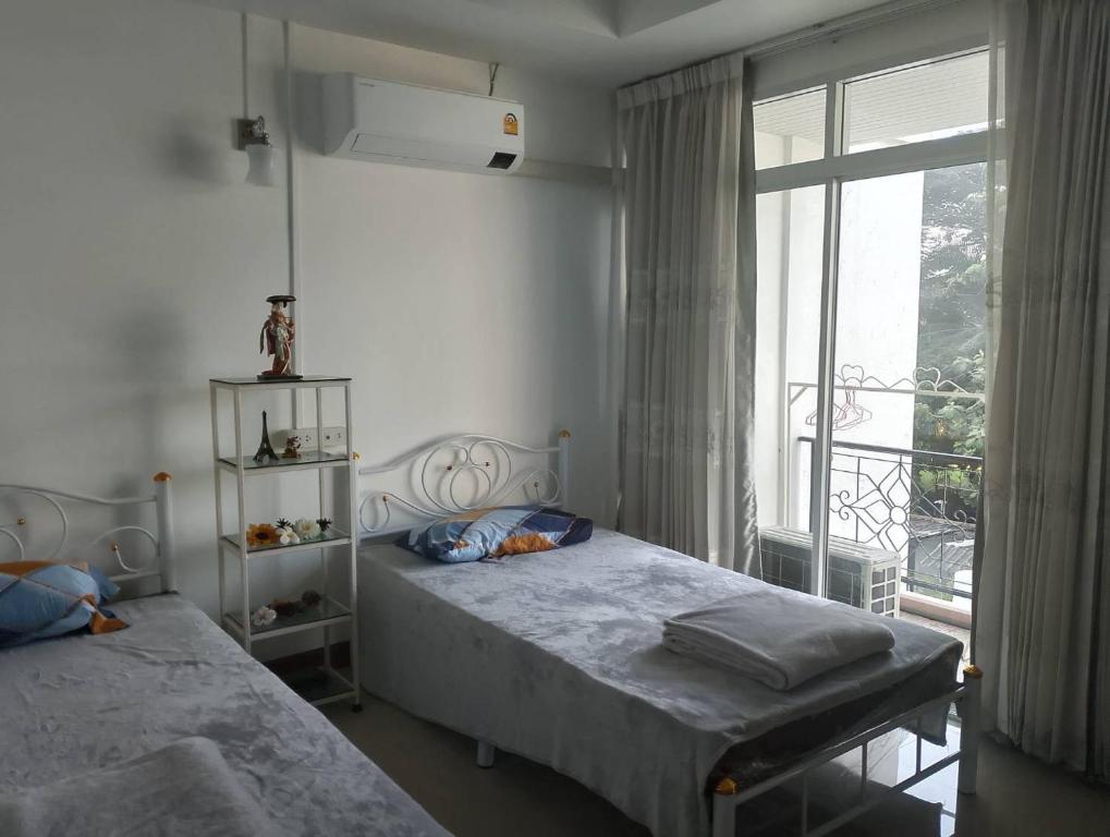 een slaapkamer met twee bedden en een groot raam bij Smart Place in Bangkok