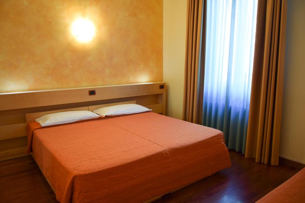 Łóżko lub łóżka w pokoju w obiekcie Hotel Losanna