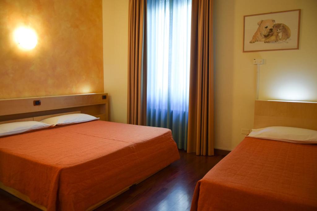 Łóżko lub łóżka w pokoju w obiekcie Hotel Losanna