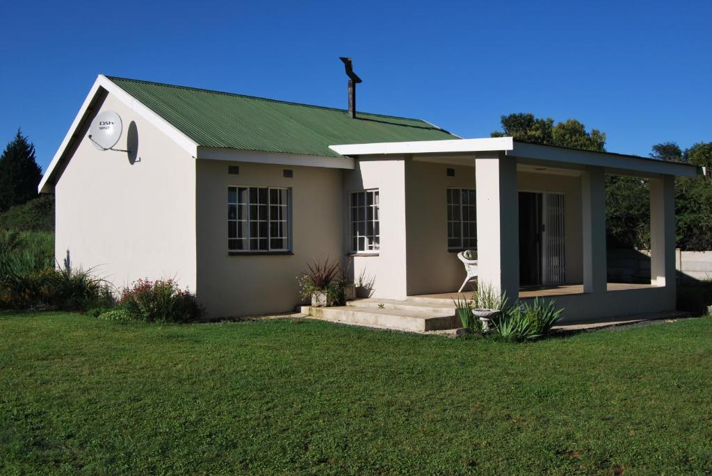 a small white chapel with a green roof at Moya Cottage in Underberg