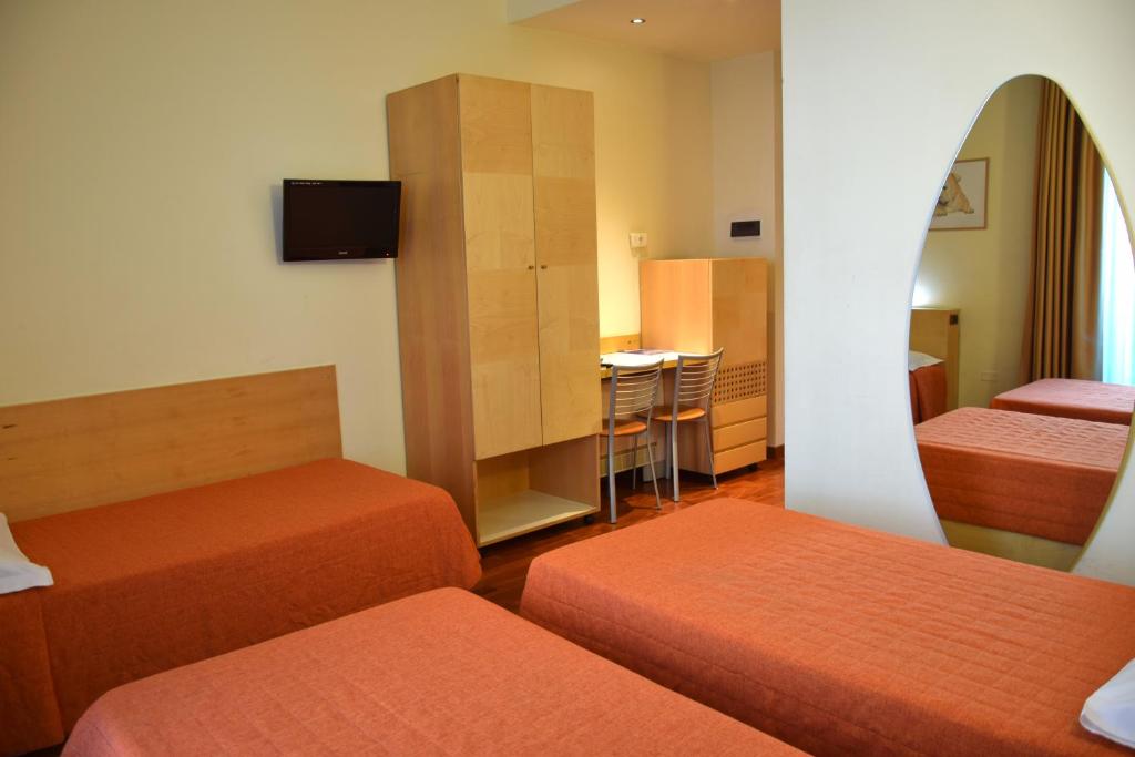 pokój hotelowy z 2 łóżkami i deską surfingową na ścianie w obiekcie Hotel Losanna w Mediolanie