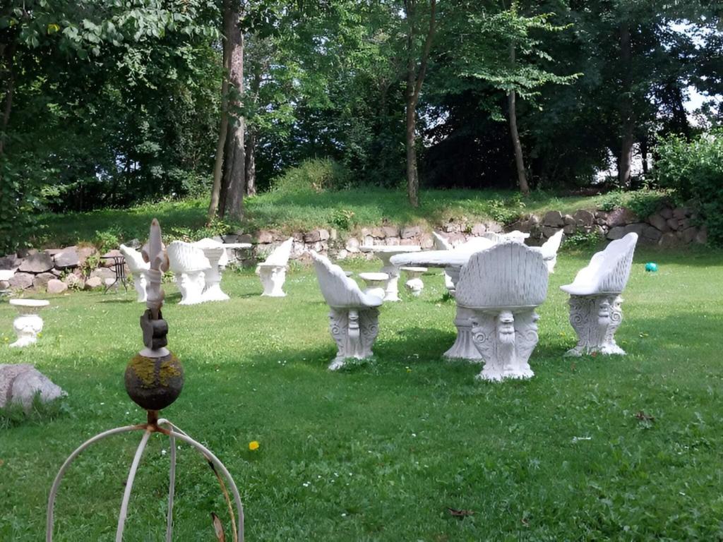 a group of white statues sitting in the grass at Queen suite in a hotel in Tranekær in Tranekær