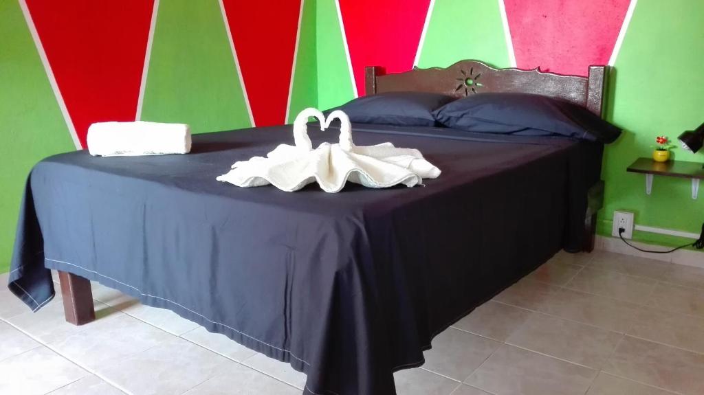Una cama con toallas blancas encima. en Appartamenti Melissa, en Playa del Carmen