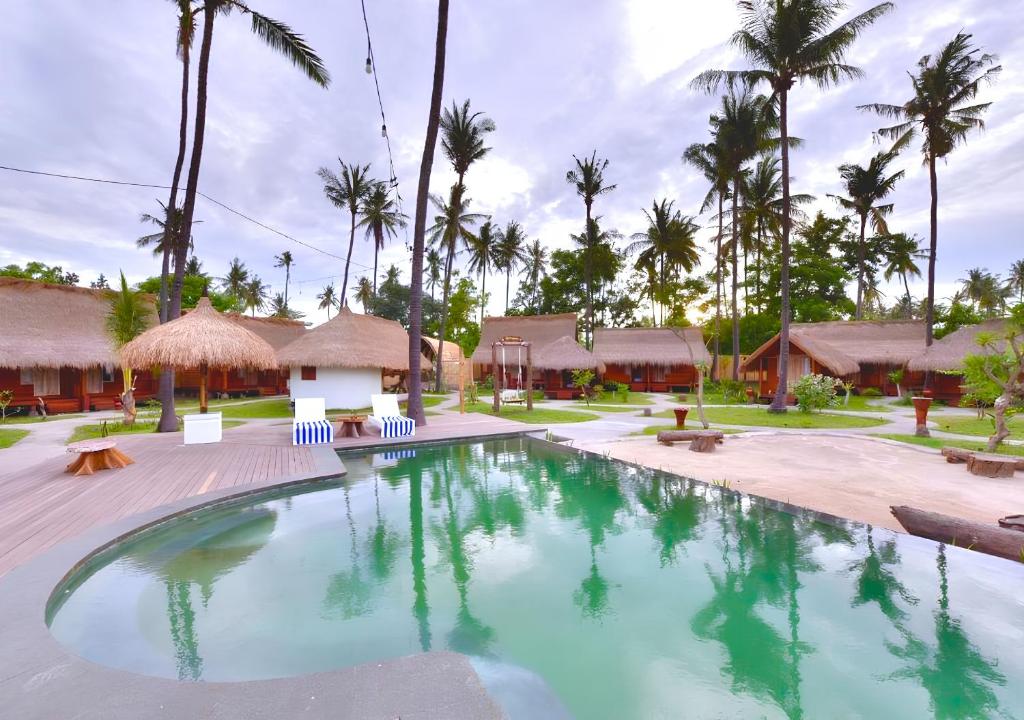 una piscina in un resort con palme di Beranda Ecolodge a Gili Air