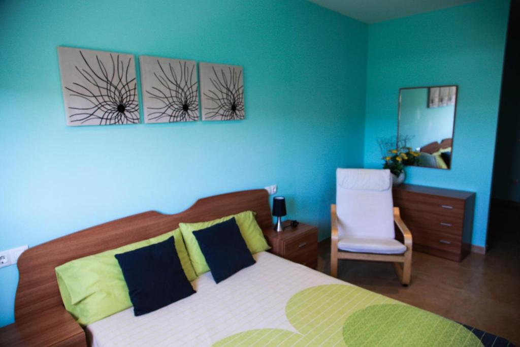 1 dormitorio con cama, silla y espejo en Apartments Bon Pas Rural, en Claravalls